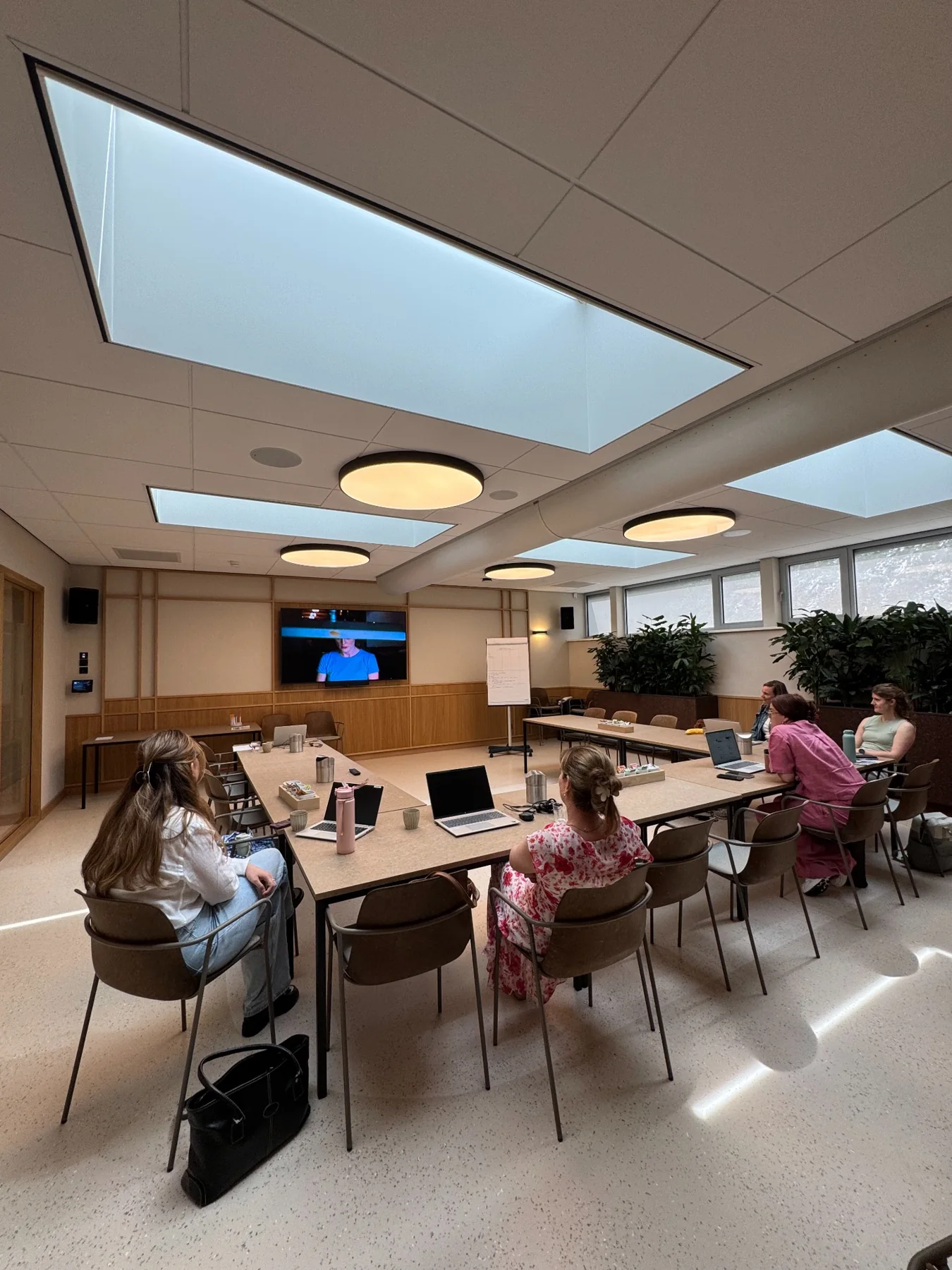 Een groep medewerkers werkt met laptops en praktijkvoorbeelden tijdens een training