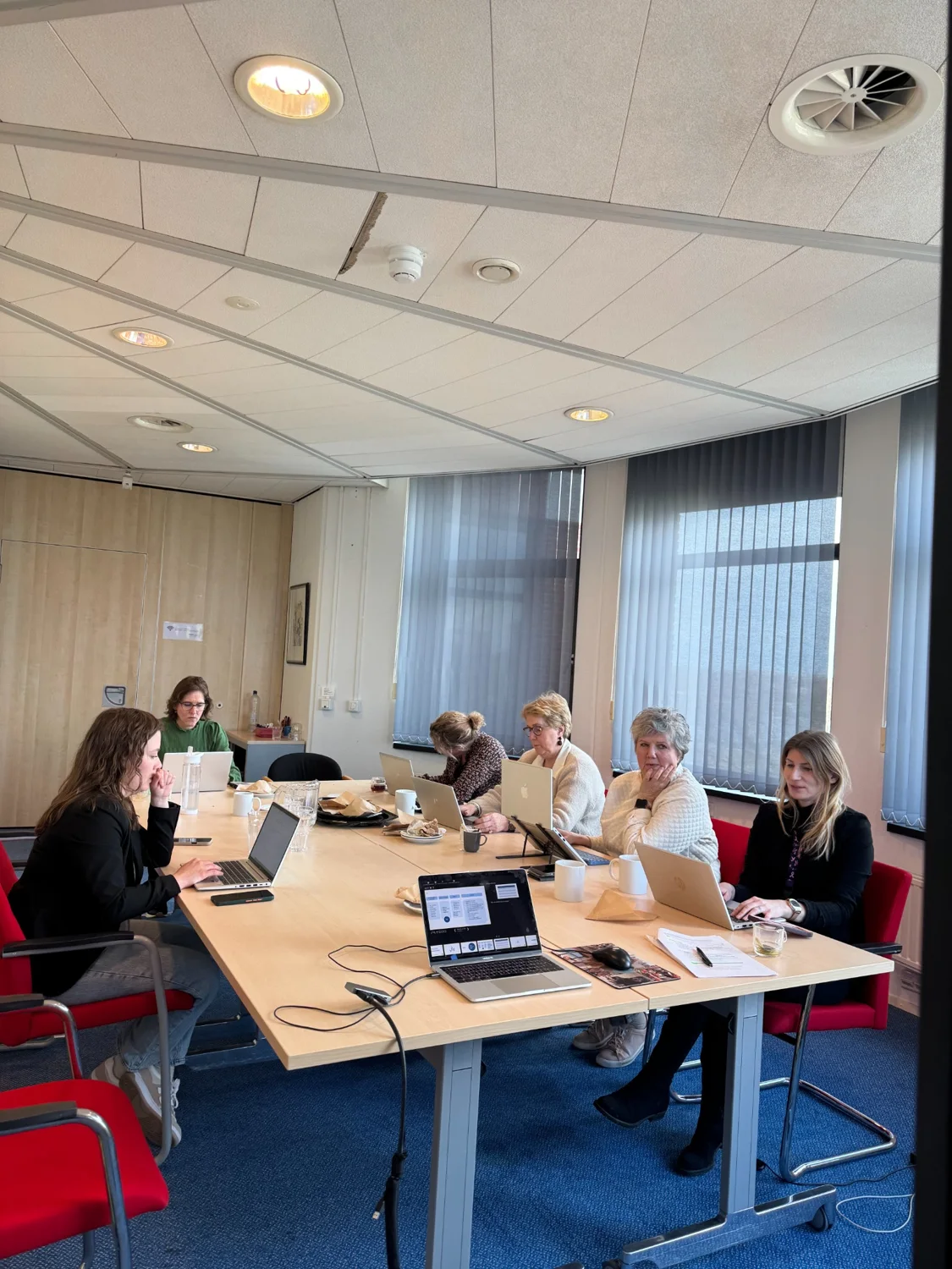 Deelnemers werken tijdens een training met laptops en eigen materiaal